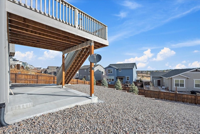 view of yard featuring stairway, a wooden deck, a fenced backyard, a patio area, and a residential view