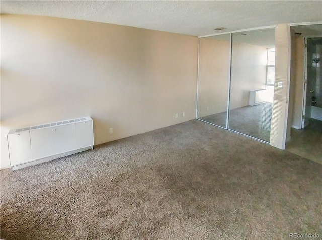 2500 S York St Unit 213, Denver, CO 80210 - unfurnished bedroom featuring radiator, carpet floors, a textured ceiling, and a closet