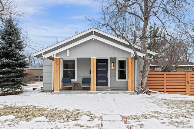 bungalow featuring fence and board and batten siding