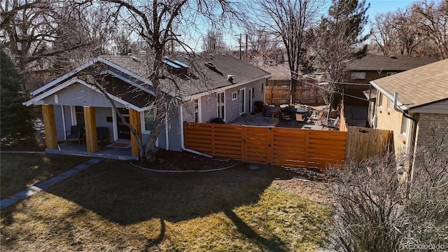 back of property featuring a patio, a lawn, and fence