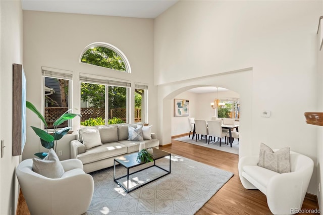 7313 Poston Way, Boulder, CO 80301 - living room featuring arched walkways, a high ceiling, and wood finished floors