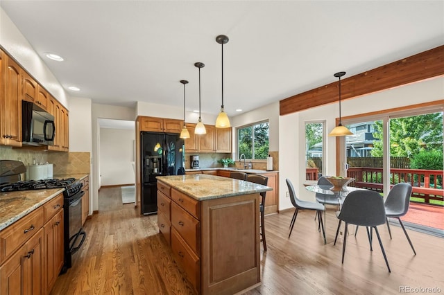 7313 Poston Way, Boulder, CO 80301 - kitchen featuring black appliances, a center island, wood finished floors, decorative backsplash, and recessed lighting