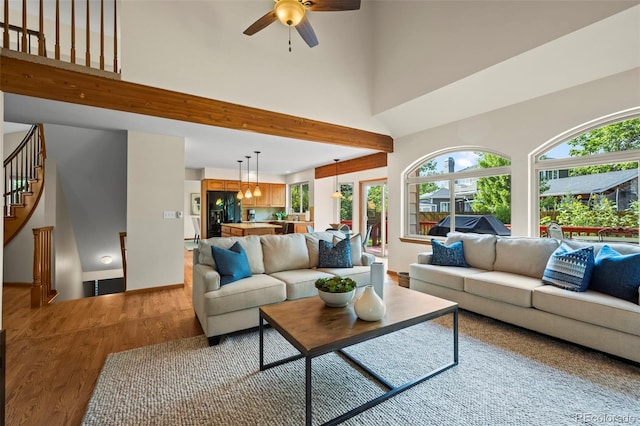 7313 Poston Way, Boulder, CO 80301 - living room with light wood finished floors, plenty of natural light, a ceiling fan, a high ceiling, and stairs