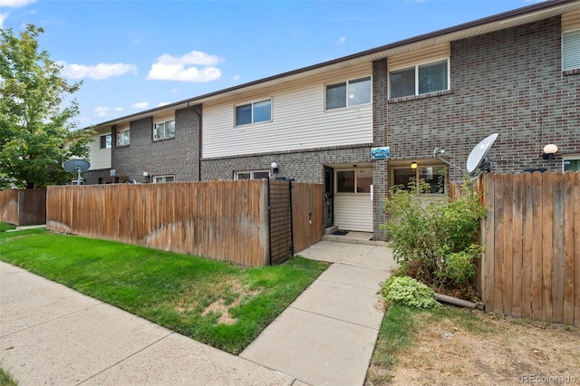 view of front of house featuring brick siding and fence