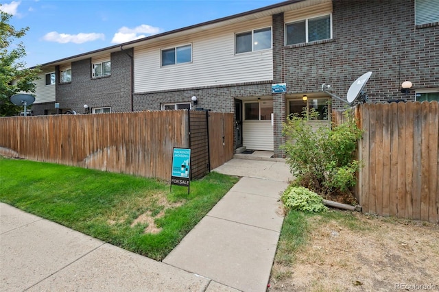 view of front of home with brick siding and fence