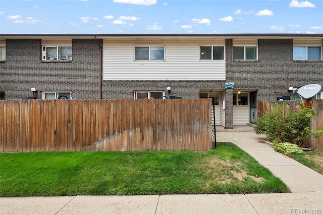 view of front of property featuring brick siding and fence