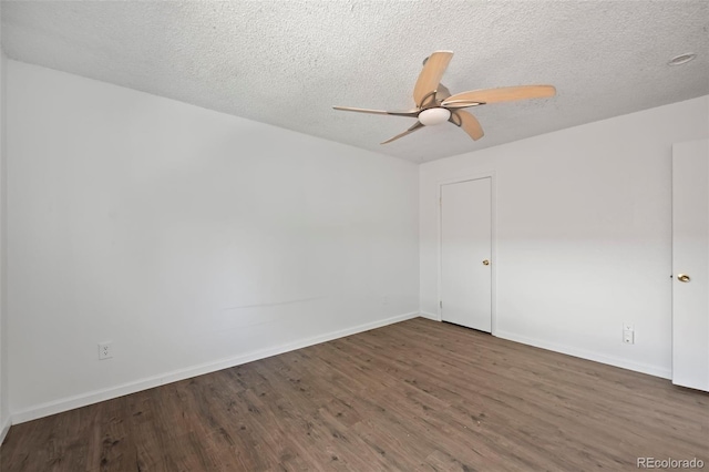 spare room featuring dark wood-style flooring, ceiling fan, a textured ceiling, and baseboards