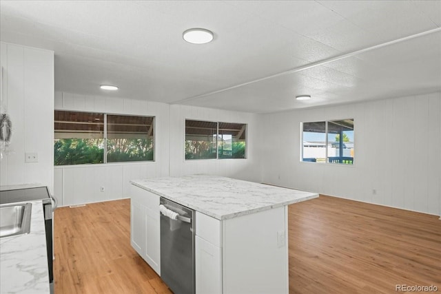 kitchen featuring light stone counters, light hardwood / wood-style flooring, white cabinets, and stainless steel dishwasher