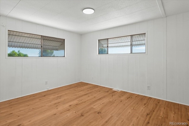 empty room with wooden walls and wood-type flooring