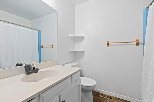 3907 E 133rd Ct, Thornton, CO 80241 - bathroom featuring wood finished floors, vanity, toilet, baseboards, and a shower with curtain