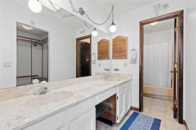 3907 E 133rd Ct, Thornton, CO 80241 - bathroom featuring double vanity, tile patterned flooring, shower / bath combo, a textured ceiling, and baseboards