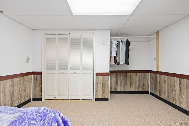 3907 E 133rd Ct, Thornton, CO 80241 - bedroom with a paneled ceiling, wooden walls, a wainscoted wall, carpet flooring, and a closet