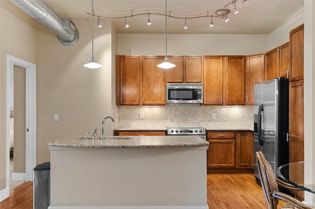 kitchen with tasteful backsplash, brown cabinets, stainless steel appliances, and a sink