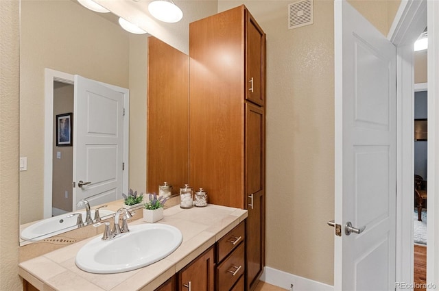 bathroom with visible vents, baseboards, and vanity