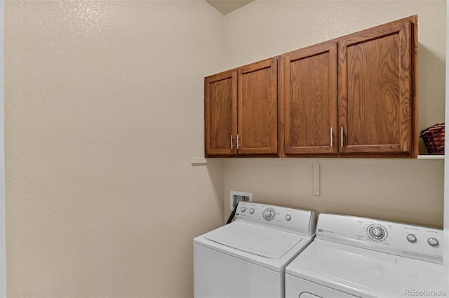 clothes washing area with cabinet space and washing machine and dryer