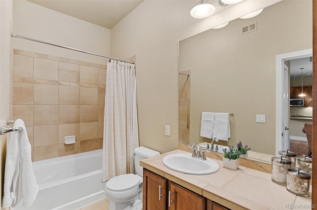 bathroom with visible vents, toilet, vanity, and shower / tub combo