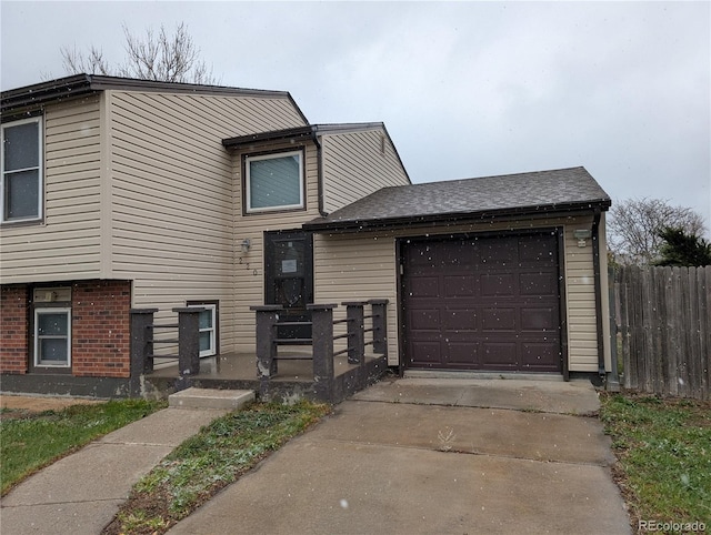 220 Mckinley Dr, Bennett, CO 80102 - split level home with an attached garage, a shingled roof, fence, and driveway
