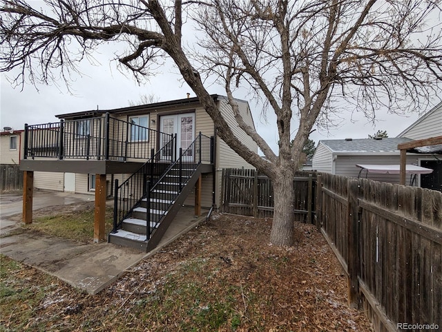 220 Mckinley Dr, Bennett, CO 80102 - rear view of property featuring a fenced backyard, a wooden deck, and stairs