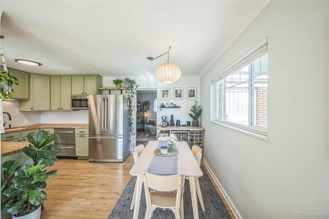 dining space with light wood-style flooring and baseboards