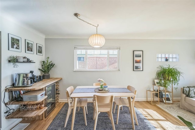 dining area with light wood-style flooring and baseboards