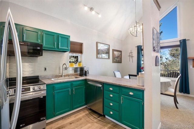 kitchen featuring pendant lighting, green cabinets, appliances with stainless steel finishes, sink, and lofted ceiling