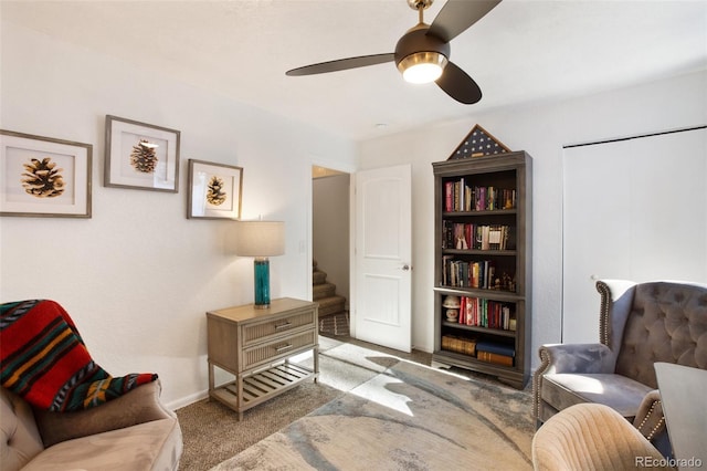 living area with ceiling fan and light carpet