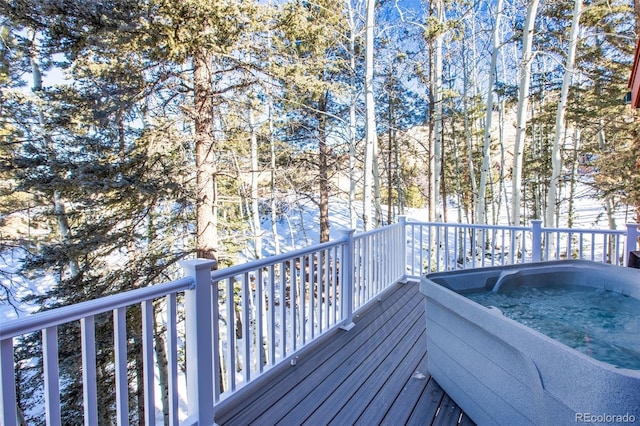 snow covered deck featuring a hot tub