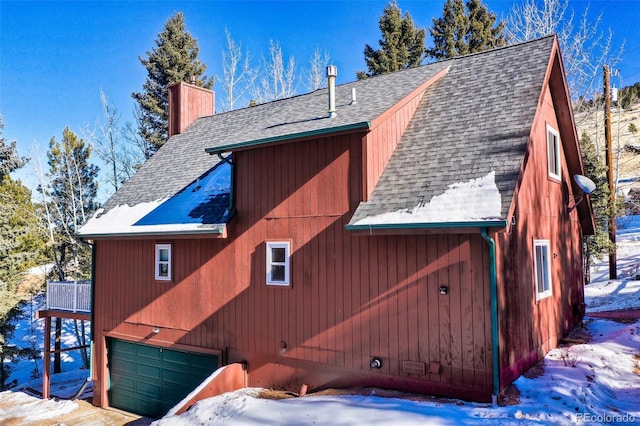 view of snow covered exterior featuring a garage