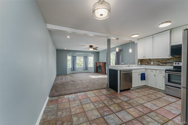 kitchen with ceiling fan, decorative light fixtures, backsplash, white cabinetry, and stainless steel appliances