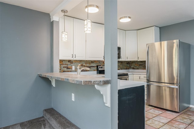 kitchen with appliances with stainless steel finishes, tasteful backsplash, white cabinets, kitchen peninsula, and pendant lighting