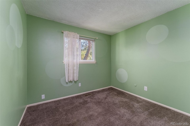 carpeted spare room with a textured ceiling