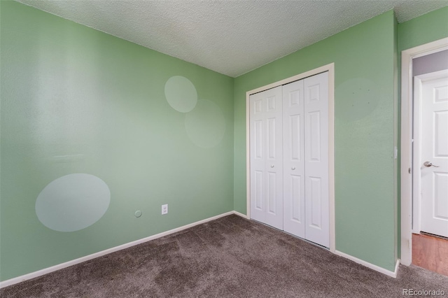 unfurnished bedroom with a textured ceiling, a closet, and carpet flooring