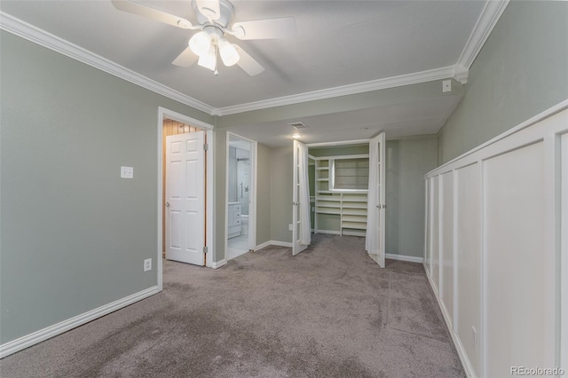 unfurnished bedroom featuring ceiling fan, light colored carpet, and crown molding