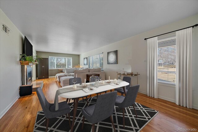 34 Skyline Dr, Wheat Ridge, CO 80215 - dining space featuring light wood-style floors, baseboards, and a glass covered fireplace
