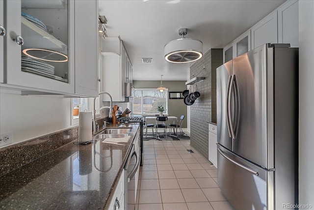34 Skyline Dr, Wheat Ridge, CO 80215 - kitchen with freestanding refrigerator, a sink, white cabinetry, glass insert cabinets, and light tile patterned flooring