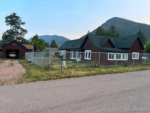 245 Lower Glenway St, Palmer Lake, CO 80133 - view of front facade with a mountain view, an outbuilding, a detached garage, and driveway