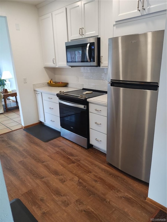 245 Lower Glenway St, Palmer Lake, CO 80133 - kitchen with appliances with stainless steel finishes, dark wood-type flooring, light countertops, and white cabinets