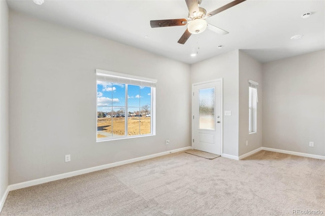 unfurnished room with light colored carpet and ceiling fan