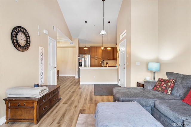 8779 S Kipling Way Unit 204, Littleton, CO 80127 - living area featuring high vaulted ceiling, light wood-style floors, and baseboards