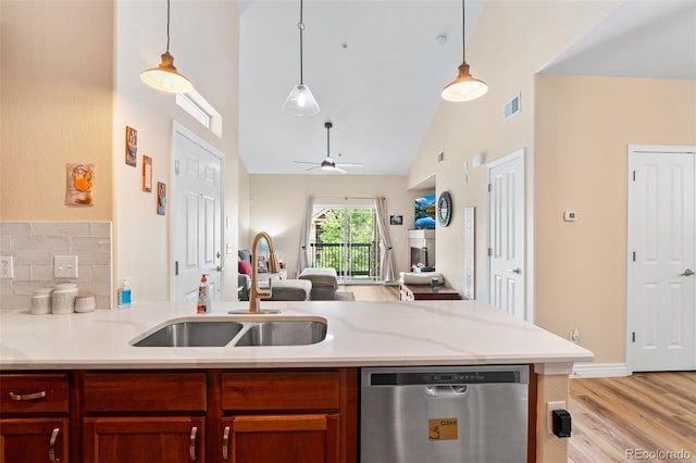 8779 S Kipling Way Unit 204, Littleton, CO 80127 - kitchen featuring stainless steel dishwasher, open floor plan, high vaulted ceiling, a sink, and light wood-style floors