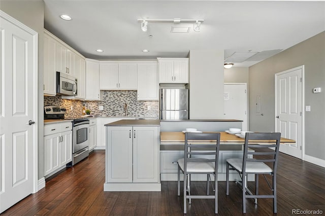1950 N Logan St Unit 1109, Denver, CO 80203 - kitchen featuring stainless steel appliances, dark wood-type flooring, backsplash, white cabinets, and recessed lighting