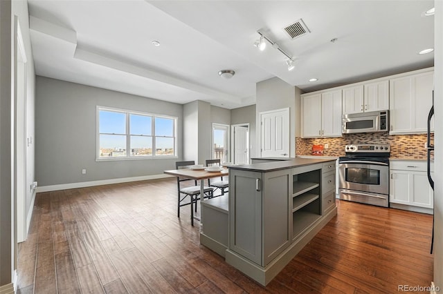 1950 N Logan St Unit 1109, Denver, CO 80203 - kitchen featuring appliances with stainless steel finishes, baseboards, white cabinets, tasteful backsplash, and recessed lighting