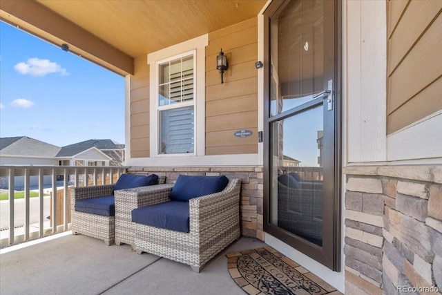 doorway to property with stone siding and a balcony