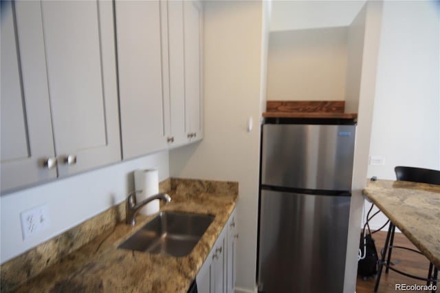 720 16th St Unit 513, Denver, CO 80202 - kitchen with freestanding refrigerator, white cabinetry, and stone counters