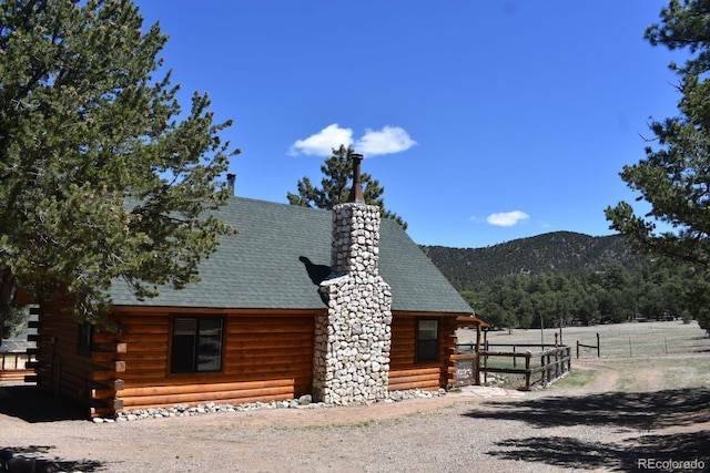 988 15th Trl, Cotopaxi, CO 81223 - exterior space with fence, a mountain view, log exterior, a chimney, and a shingled roof