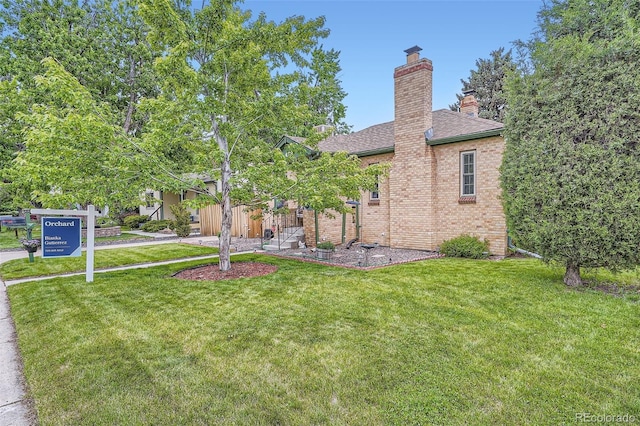5704 Ammons St, Arvada, CO 80002 - view of front facade featuring brick siding, a front lawn, a chimney, and a shingled roof