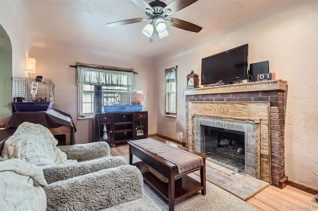 5704 Ammons St, Arvada, CO 80002 - living area with wood finished floors, ceiling fan, a tile fireplace, baseboards, and arched walkways