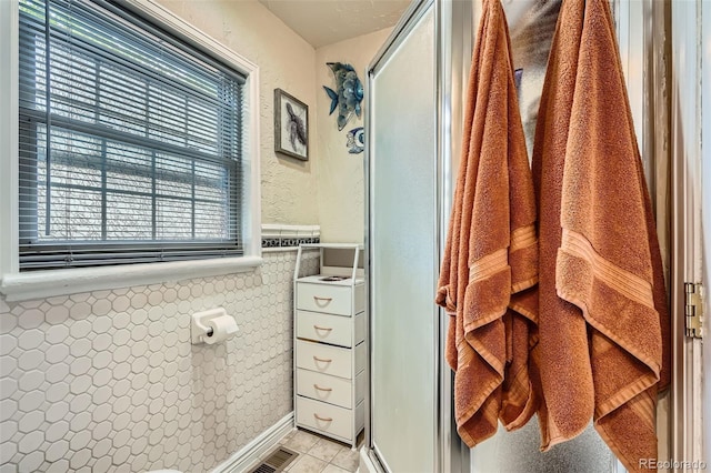 5704 Ammons St, Arvada, CO 80002 - bathroom featuring tile patterned flooring, wainscoting, and a stall shower