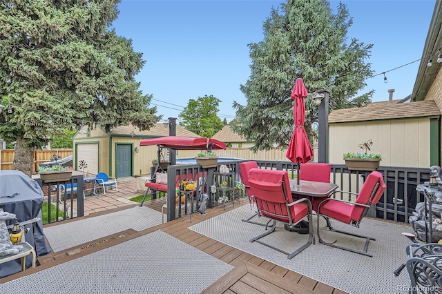 5704 Ammons St, Arvada, CO 80002 - wooden terrace featuring outdoor dining area and an outbuilding