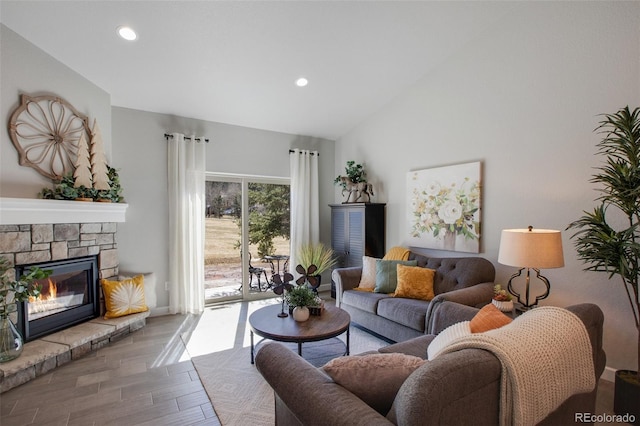 living room featuring a stone fireplace, wood-type flooring, and high vaulted ceiling